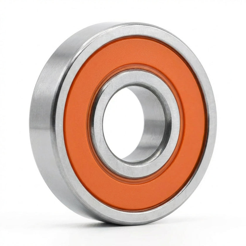 Edge Bearing with orange seals and a silver steel ring, standing upright on its edge against a white background