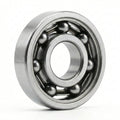 Open Edge Bearing standing on its edge on a white background, its steel balls and cage visible between the rings