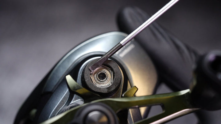 A pick lifts the small wire clip that holds the spool bearing